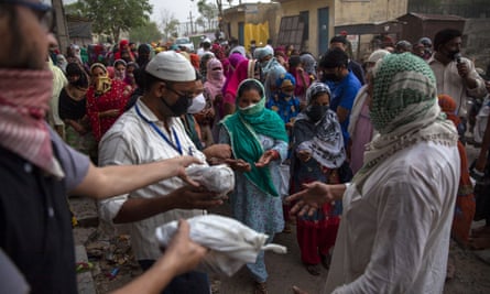Des musulmans distribuent de la nourriture aux pauvres et aux nécessiteux dans la région de Mustafabad, récemment touchée par des émeutes