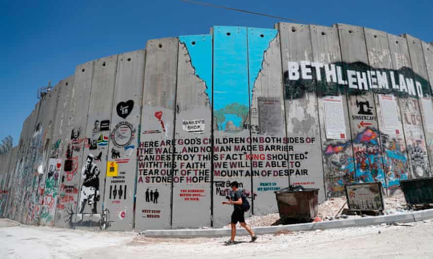 Une personne passe devant des graffitis dans la ville cisjordanienne de Bethléem en 2017