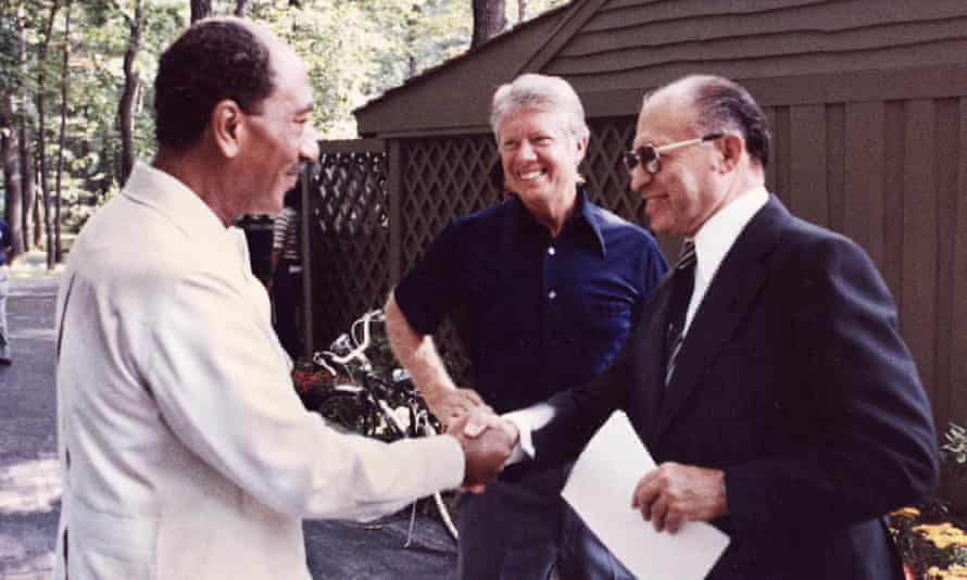 Le président égyptien Anwar Sadate, à gauche, serrant la main du Premier ministre israélien Menachem d'Israël, avec Jimmy Carter regardant la retraite présidentielle américaine à Camp David en 1978, avant l'annonce des accords de paix historiques l'année suivante.