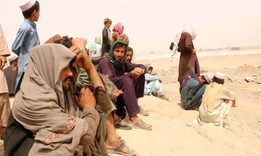 Des personnes bloquées à la frontière pakistano-afghane attendent au bord de la route