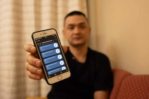 un homme tient son téléphone devant la caméra.