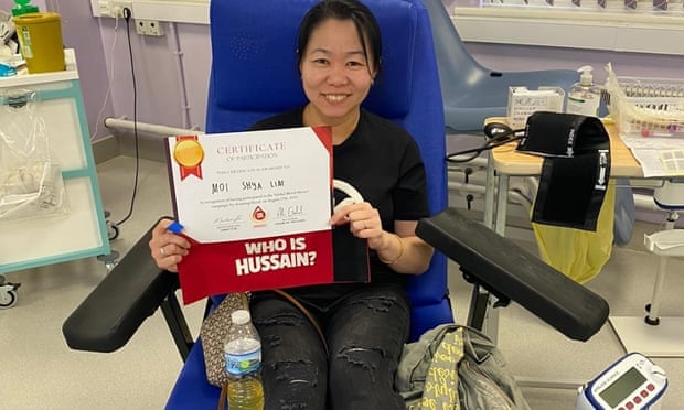 Une donneuse montre son certificat après avoir donné du sang à Birmingham