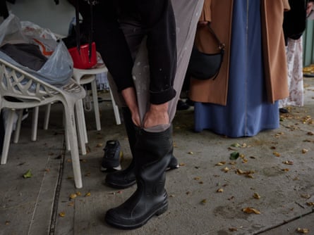 Le père de Mohammed met ses bottes alors qu'il se prépare à sacrifier des moutons pour l'Aïd al-Adha