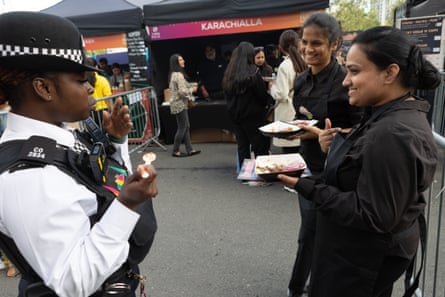 Les convives partagent de la nourriture avec un officier de police lors du festival mondial de la cuisine halal.