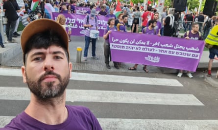 Alon-Lee Green prend un selfie avec des membres du groupe debout derrière des banderoles